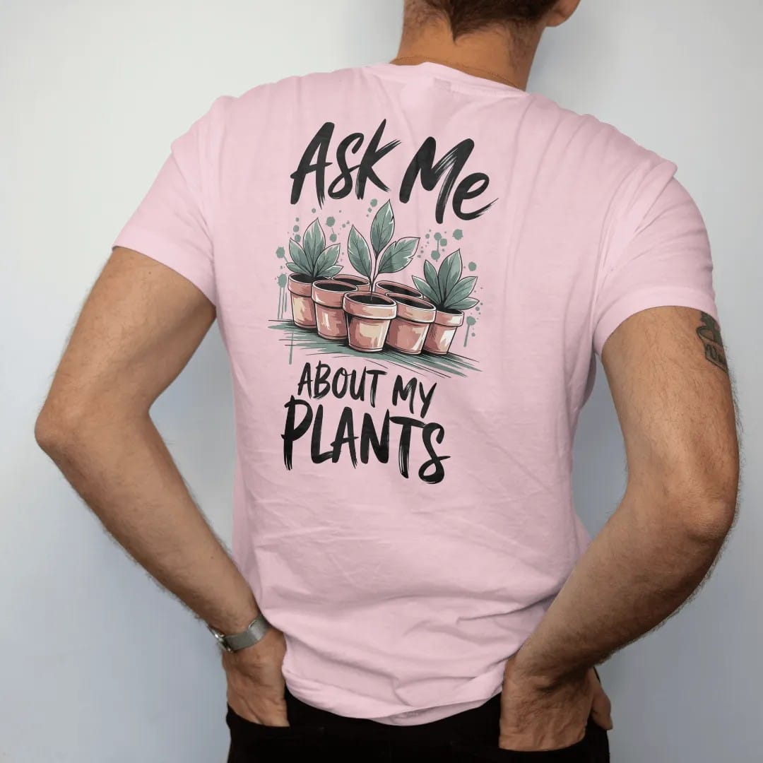 Man wearing a Blossom tee, seen from the back: a cluster of five small pots with one leaf pointing like a raised hand, "ASK ME" in loose brush script above and "ABOUT MY PLANTS" below, painted in loose watercolor and ink with soft deep green,…