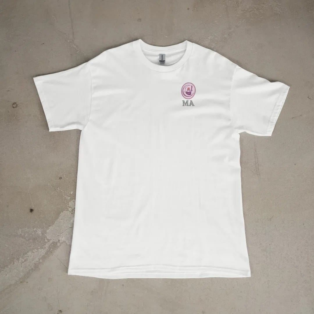 Front of a White tee laid flat, with the small Midnight Apothecary logo on the left chest.