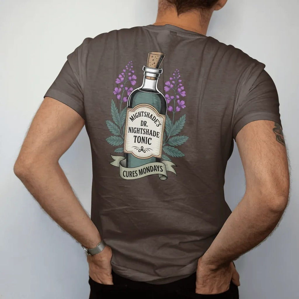 Man wearing a Espresso tee, seen from the back: back print: A vintage medicine-show bottle with a tall label, flanked by nightshade flowers, "DR. NIGHTSHADE'S" arched on top, "MIDNIGHT TONIC" on the label, "CURES MONDAYS" in a ribbon, detailed…