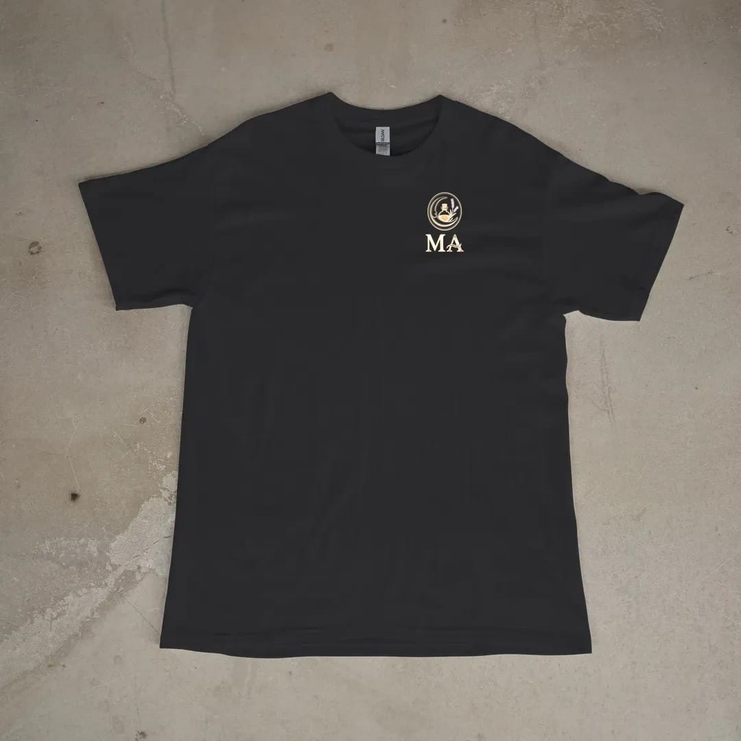 Front of a Black tee laid flat, with the small Midnight Apothecary logo on the left chest.