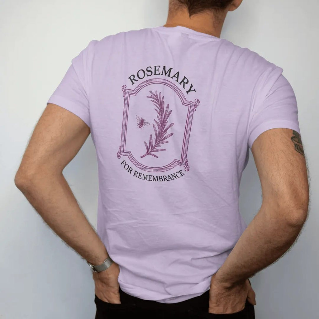 Man wearing a Orchid tee, seen from the back: back print: A single long sprig of rosemary in fine engraving with a tiny bee, "ROSEMARY" above and "FOR REMEMBRANCE" in small caps below, antique apothecary-label engraving, fine crosshatching, ornate…