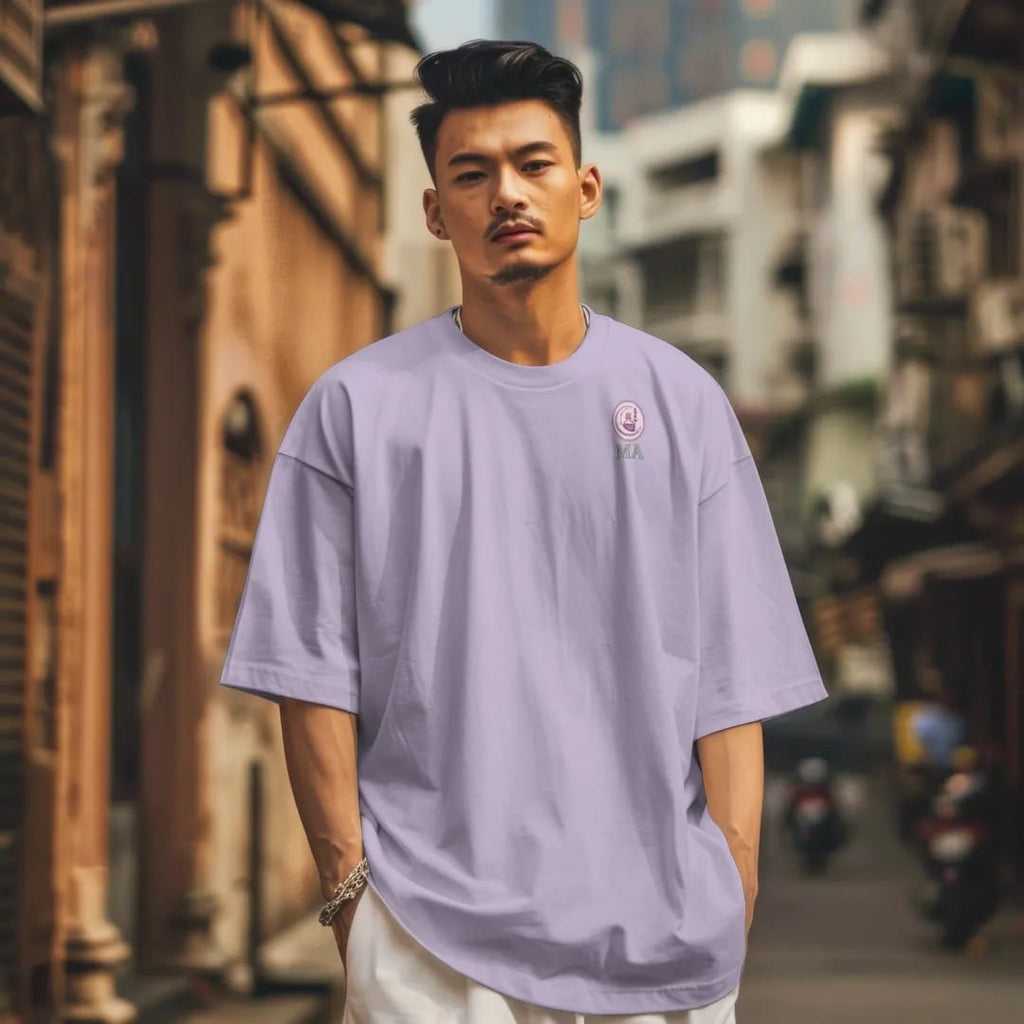 Man in a Orchid tee on a city street, with the small Midnight Apothecary logo on the left chest.
