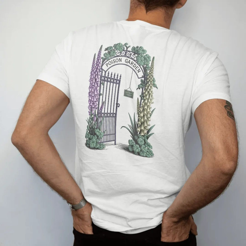 Man wearing a White tee, seen from the back: back print: an iron garden gate wrapped in foxglove, belladonna and hemlock blossoms, "POISON GARDEN" arched over the gate and "DO NOT TOUCH" on a tiny hanging sign, detailed vintage etching, fine…
