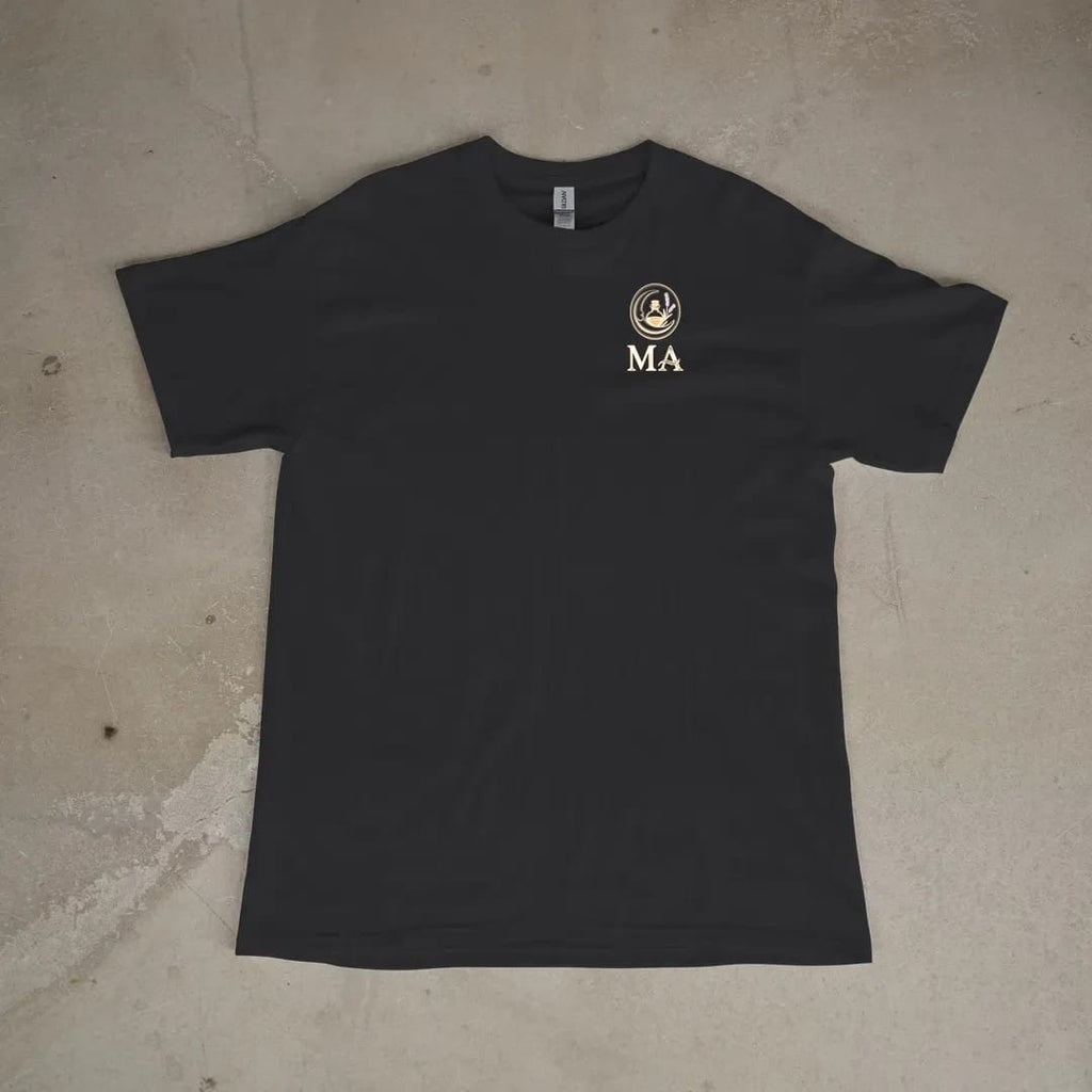Front of a Black tee laid flat, with the small Midnight Apothecary logo on the left chest.