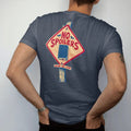 Man wearing a Midnight tee, seen from the back: a diamond caution sign with a tombstone and closed book reading No Spoilers on a graveyard post, with Beyond This Point on a plank, in pulp halftone cream, red, yellow and blue.
