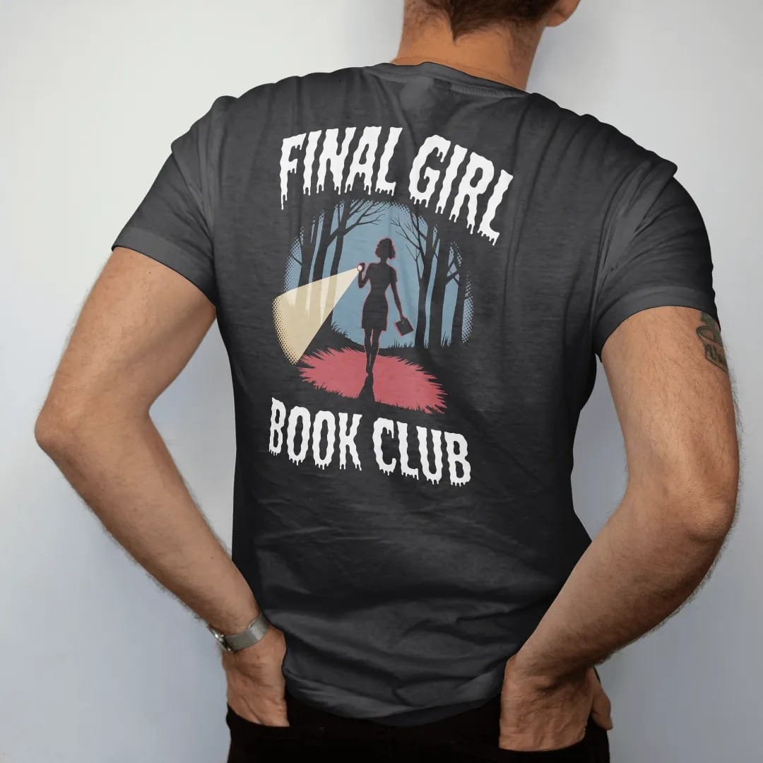 Man wearing a Black tee, seen from the back: a woman silhouette with a flashlight and a paperback in a dark woods under Final Girl with Book Club below, in pulp halftone cream, red, yellow and blue.