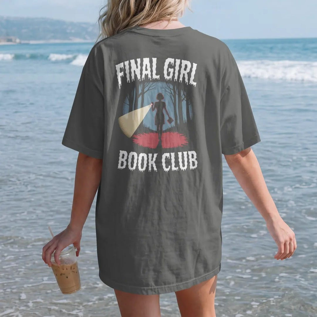 Woman on the beach in a Pepper tee, back view: a woman silhouette with a flashlight and a paperback in a dark woods under Final Girl with Book Club below, in pulp halftone cream, red, yellow and blue.