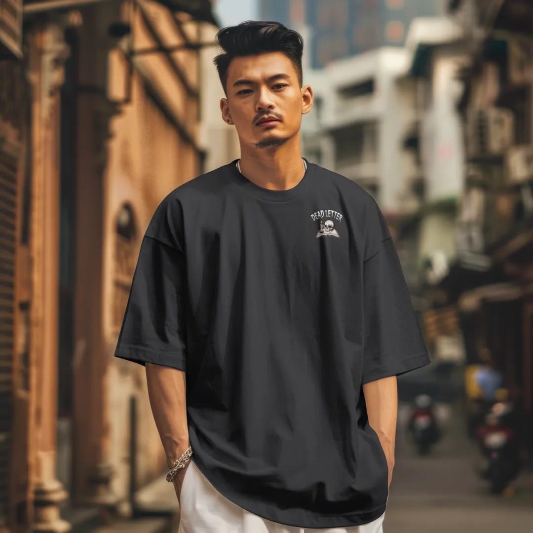 Man in a Black tee on a city street, with the small Dead Letter Book Club logo on the left chest.