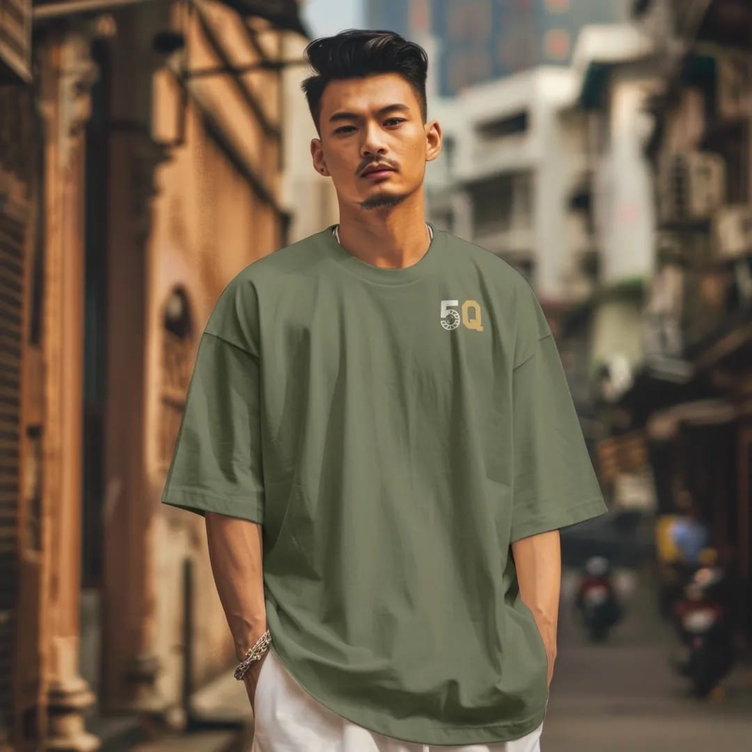 Man in a Moss tee on a city street, with the small Fifth Quarter Tailgate logo on the left chest.