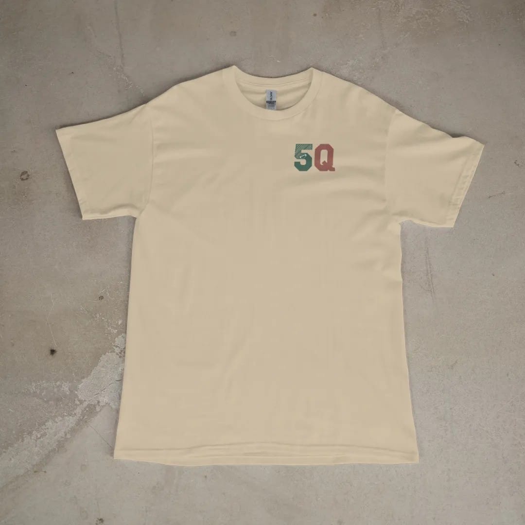 Front of a Sandstone tee laid flat, with the small Fifth Quarter Tailgate logo on the left chest.