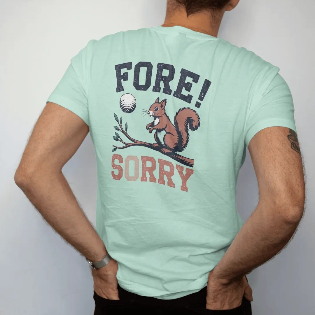 Man wearing a Chalky Mint tee, seen from the back: a golf ball flying toward a startled squirrel on a branch, with "FORE!" and "SORRY" in chunky faded collegiate block letters, printed in faded fairway green, washed navy, faded flag red and sand…