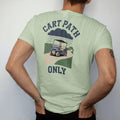 Man wearing a Light Green tee, seen from the back: a vintage golf cart puttering along a winding path under rain clouds, with "CART PATH" and "ONLY" in chunky rounded 70s serif letters, printed in faded fairway green, washed navy, faded flag red…