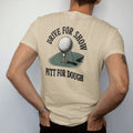 Man wearing a Sandstone tee, seen from the back: a golf ball rolling toward the cup on a sloping green, with "DRIVE FOR SHOW" and "PUTT FOR DOUGH" in loopy 1970s script, printed in faded fairway green, washed navy, faded flag red and sand tan with…