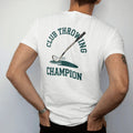 Man wearing a White tee, seen from the back: a golf club tumbling end over end through the air toward a pond, with "CLUB THROWING" and "CHAMPION" in chunky faded collegiate block letters, printed in faded clubhouse cream, sage grass green, washed…