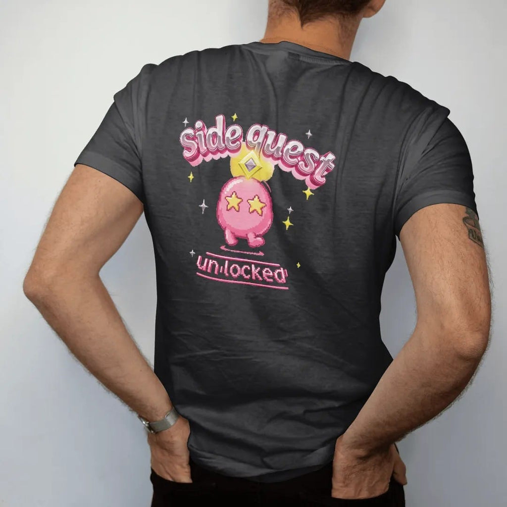 Man wearing a Black tee, seen from the back: blip the pixel slime under a yellow quest marker, with side quest arched in pink and silver chrome bubble letters and unlocked in a lime pixel banner.