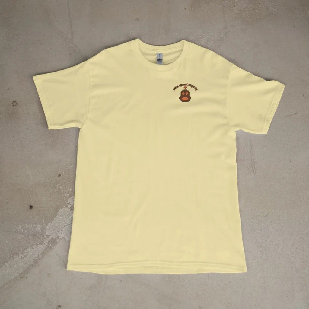 Front of a Butter tee laid flat, with the small Side Quest Supply logo on the left chest.