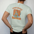 Man wearing a Bay tee, seen from the back: blip the pixel slime holding a sandwich in front of a glowing pixel fridge, under save point in rounded arcade letters with a snack break ribbon, in brown, rust, moss and denim.