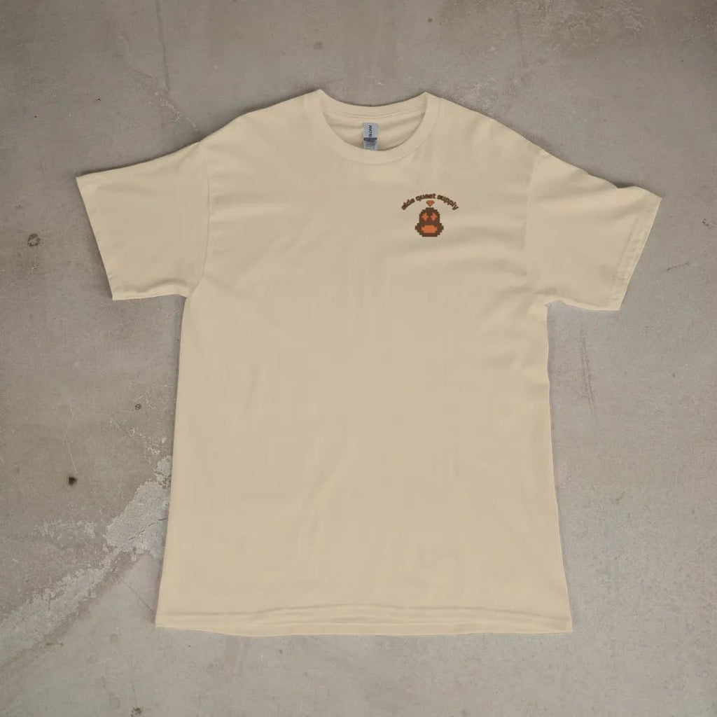 Front of a Sandstone tee laid flat, with the small Side Quest Supply logo on the left chest.