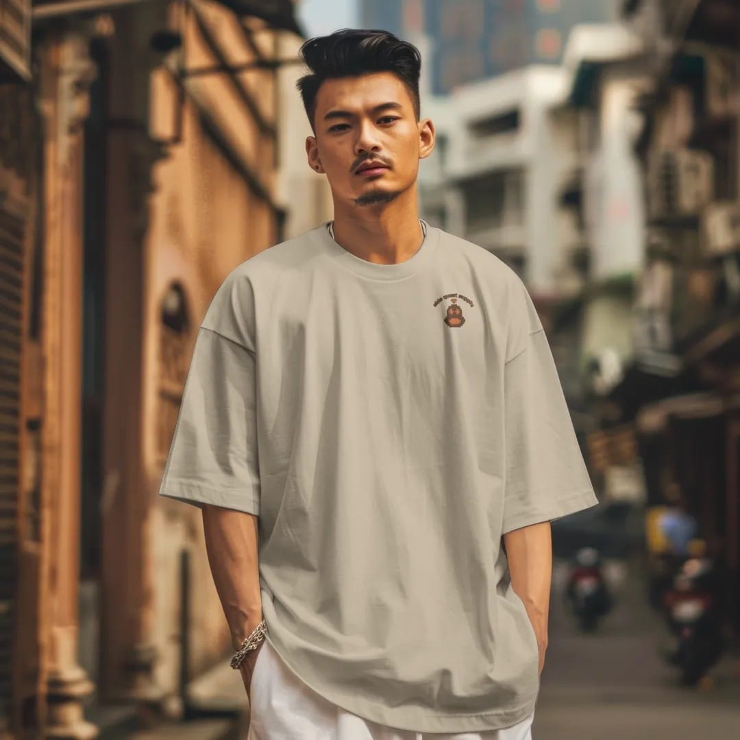 Man in a Sandstone tee on a city street, with the small Side Quest Supply logo on the left chest.