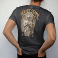 Man wearing a Black tee, seen from the back: a classical angel with folded wings and a halo of TV static in airbrushed chrome, under Velvet Static in tall gothic blackletter, in bone cream, chrome silver and antique gold.