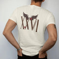 Man wearing a Ivory tee, seen from the back: Tall Roman serif numerals XXVI with a pair of feathered wings above and a thorny rose vine, in espresso and oxblood.
