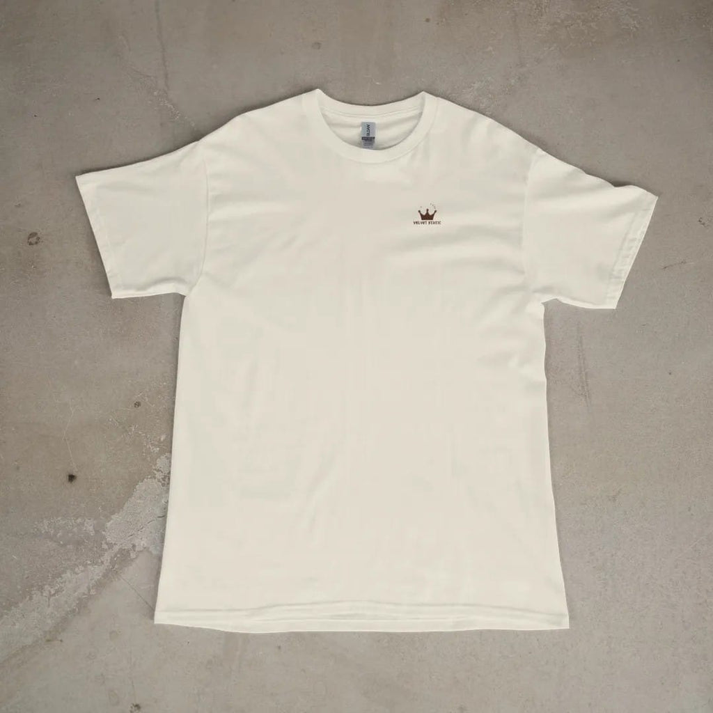 Front of a Ivory tee laid flat, with the small Velvet Static logo on the left chest.