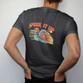 Man wearing a Black tee, seen from the back: a helmeted turbo snail mascot speeding over rally stripes under arched Spool It Up lettering, in cream, rally orange, signal yellow and teal.