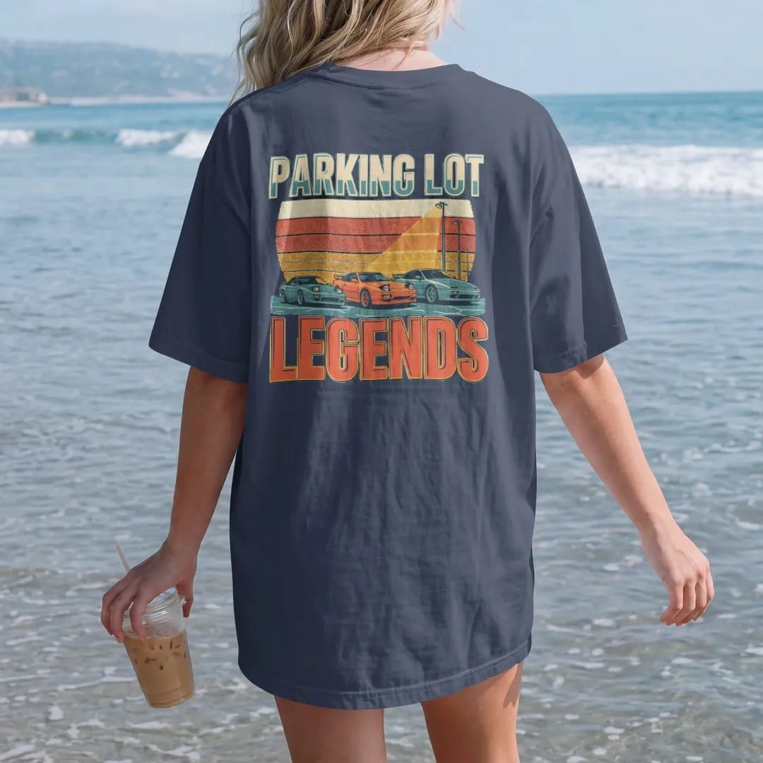 Woman on the beach in a Navy tee, back view: three generic sport coupes under a parking-lot light with a striped retro sunset, Parking Lot Legends in big poster type, in cream, orange, yellow and teal.