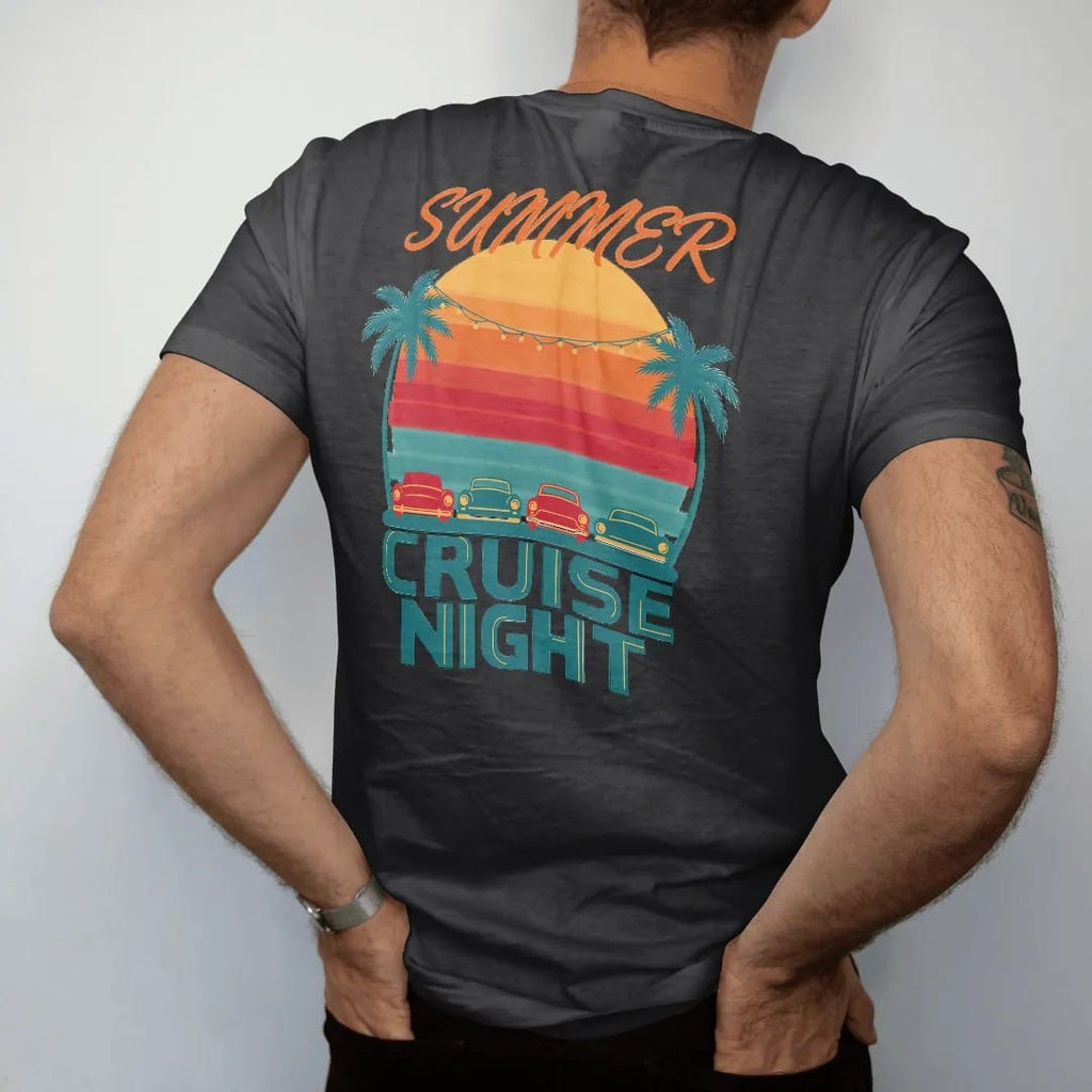 Man wearing a Black tee, seen from the back: a row of generic classic cars facing a striped retro sunset with palms and string lights, Summer in script over Cruise Night, in yellow, orange, red and teal.