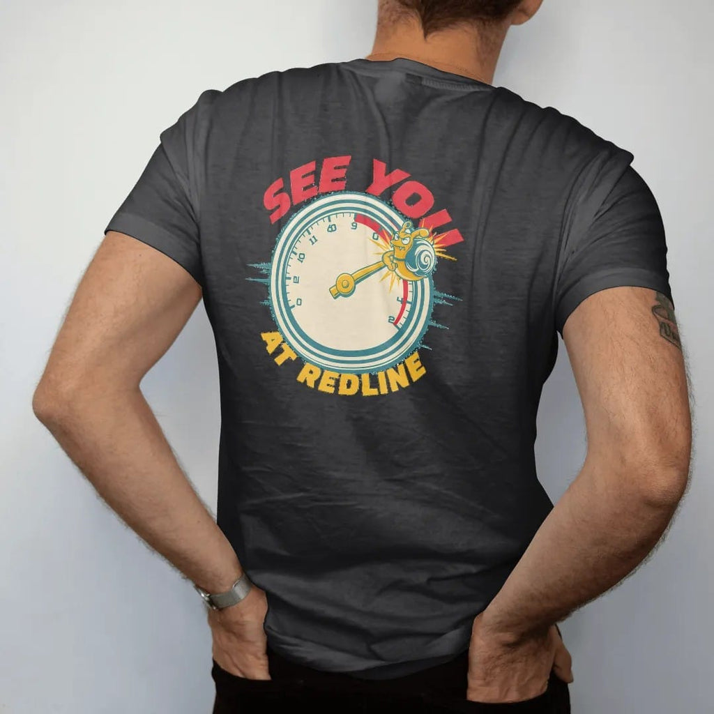 Man wearing a Black tee, seen from the back: a vintage tachometer with the needle in the red zone and the turbo snail clinging to the tip, See You At Redline lettering, in red, yellow, cream and teal.