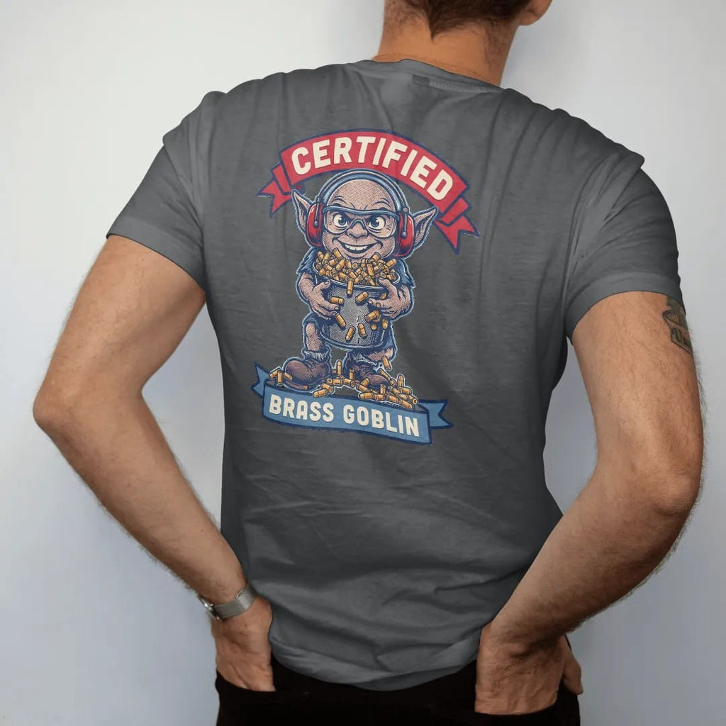 Man wearing a Graphite tee, seen from the back: a goblin in ear protection and safety glasses hugging an overflowing bucket of spent brass, Certified Brass Goblin lettering, in brass gold, cream, red and blue.