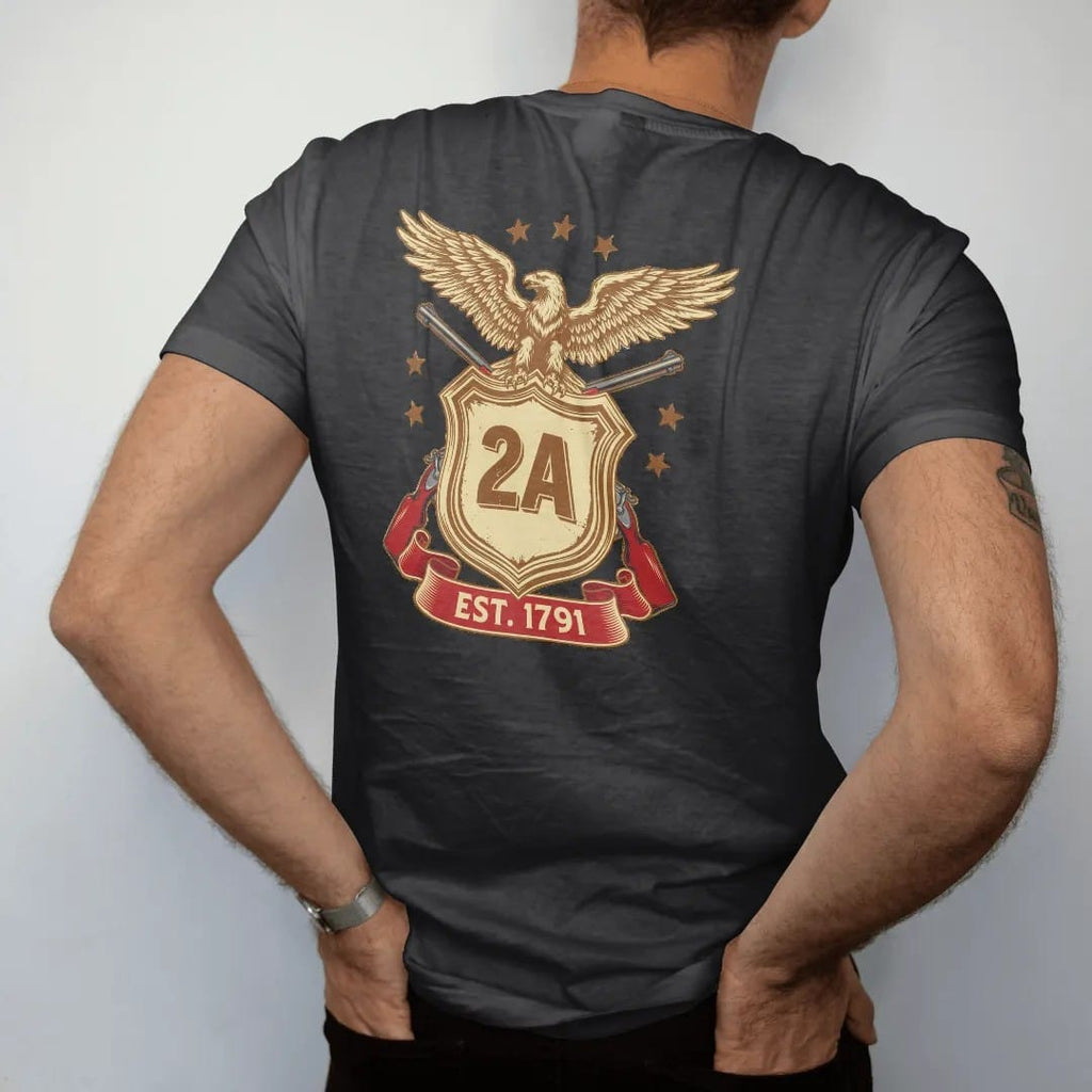 Man wearing a Black tee, seen from the back: a heraldic shield with 2A at the center over two crossed generic rifles and a spread-winged eagle, Est. 1791 on a ribbon, in brass gold, cream, red and blue.