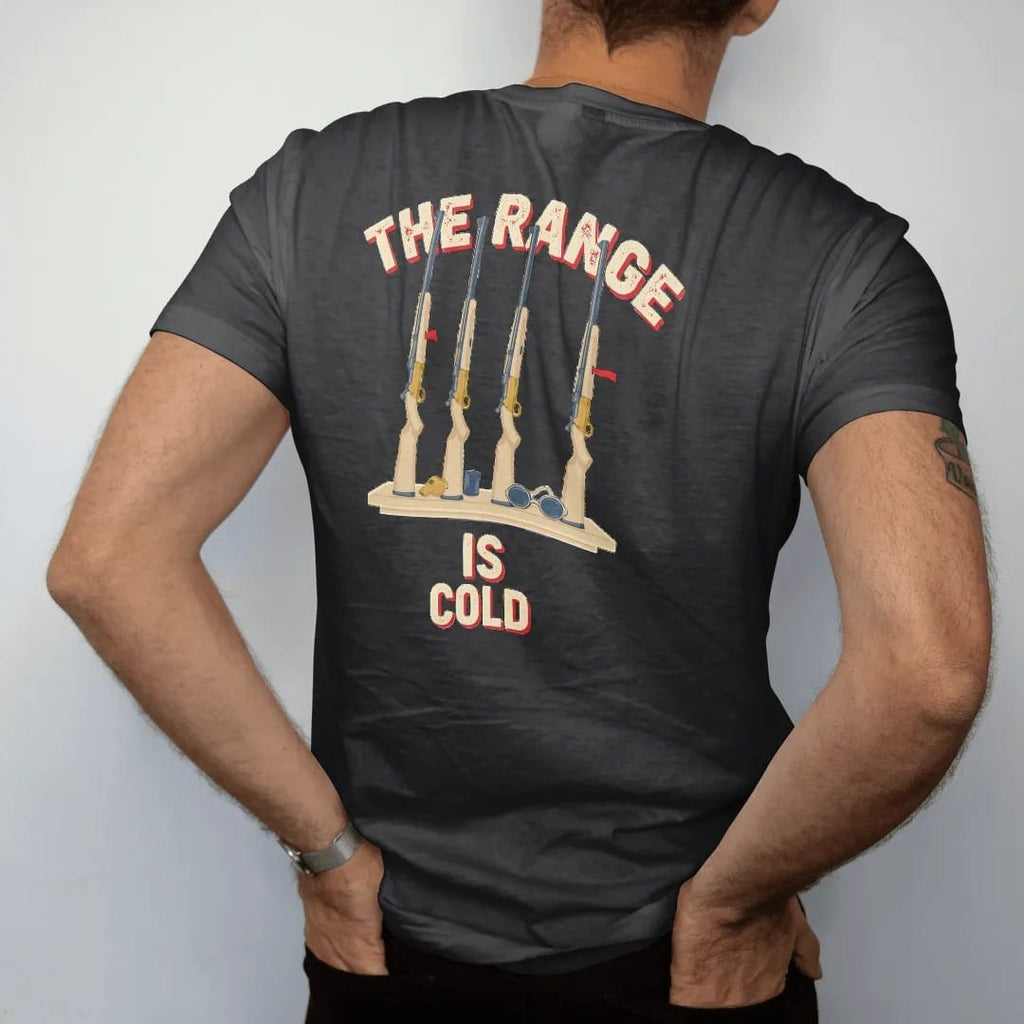 Man wearing a Black tee, seen from the back: a rack of generic rifles with open actions and chamber flags beside a whistle and safety glasses, The Range Is Cold lettering, in cream, red, brass gold and blue.