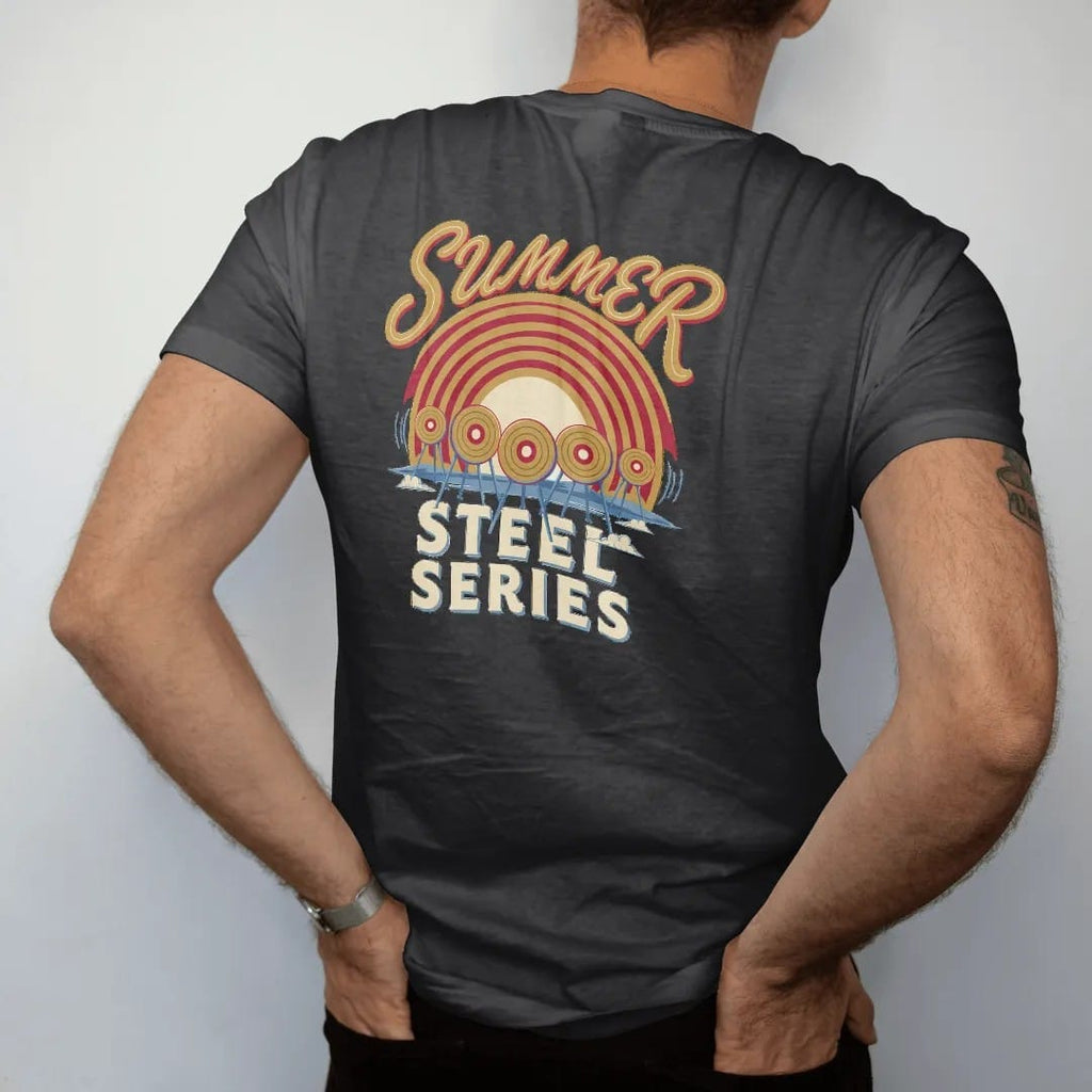 Man wearing a Black tee, seen from the back: round steel targets swinging in front of a striped retro sunset over a dusty range, Summer in script over Steel Series, in brass gold, red, cream and blue.