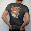 Man wearing a Black tee, seen from the back: round steel targets swinging in front of a striped retro sunset over a dusty range, Summer in script over Steel Series, in brass gold, red, cream and blue.