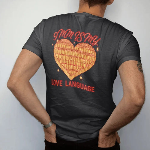 Man wearing a Black tee, seen from the back: a tattoo-flash heart made of stacked 9mm brass cartridges with sparkles, 9mm Is My Love Language lettering, in brass gold, red and cream.