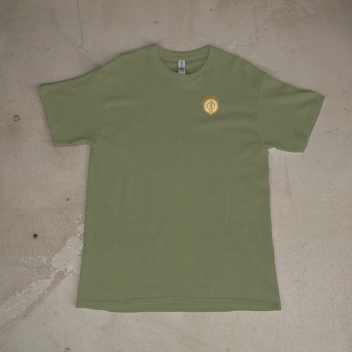 Front of a Moss tee laid flat, with the small Brass & Powder Co. logo on the left chest.