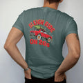 Man wearing a Blue Spruce tee, seen from the back: a boxy 80s sedan on giant chrome rims with a Christmas tree on the roof and string lights in falling snow, under Sleigh Ride and over On 26s.