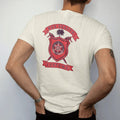 Man wearing a Ivory tee, seen from the back: a club crest: a red shield with a chrome wheel, crossed spray guns and a palmetto tree, Box Season and Customs on ribbon banners.