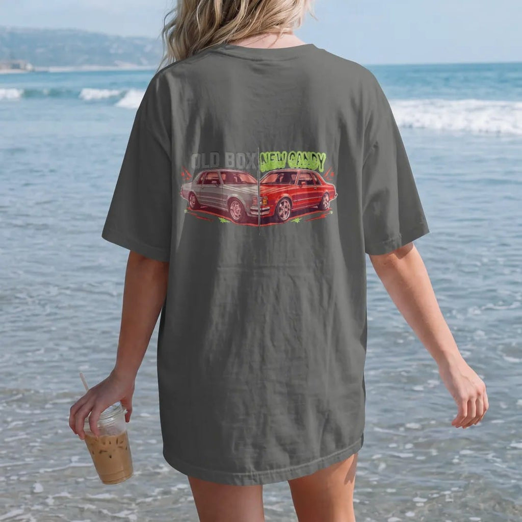 Woman on the beach in a Pepper tee, back view: a split before-and-after of a boxy sedan, primer on stock wheels versus candy paint on big chrome rims, with Old Box over the left and New Candy over the right.