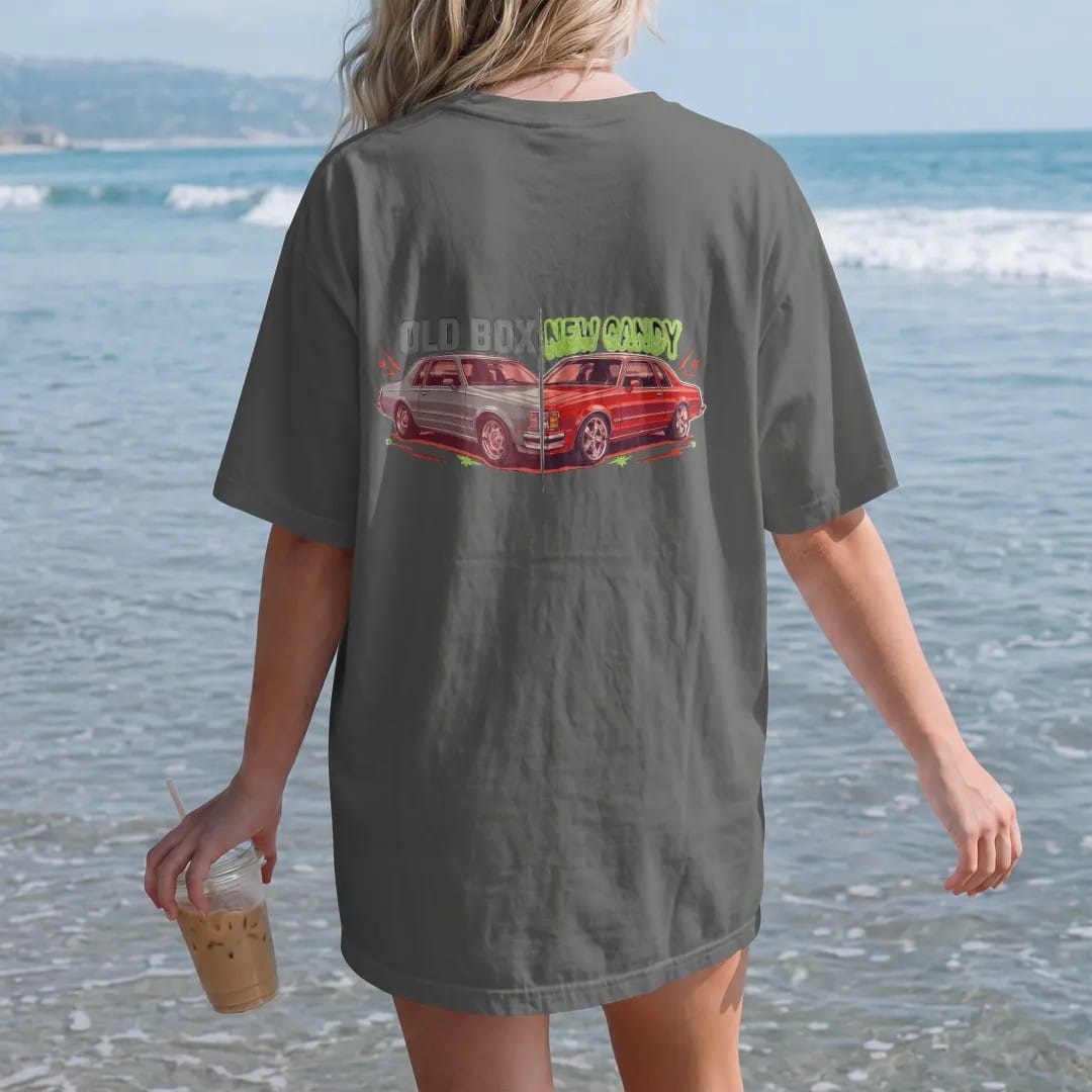 Woman on the beach in a Pepper tee, back view: a split before-and-after of a boxy sedan, primer on stock wheels versus candy paint on big chrome rims, with Old Box over the left and New Candy over the right.