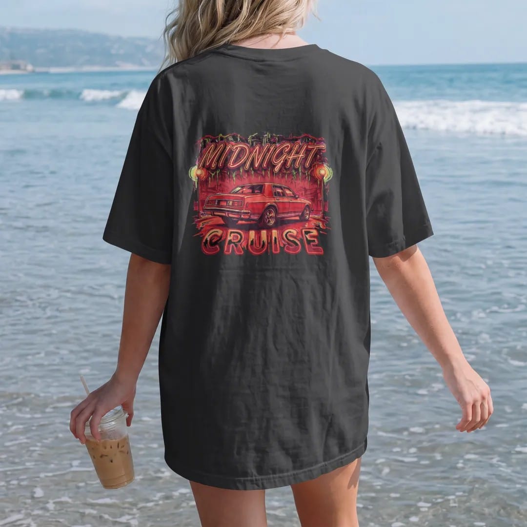 Woman on the beach in a Black tee, back view: a boxy sedan sitting high on chrome rims rolling under streetlights and mossy oaks with neon glow, under Midnight in neon script and over Cruise.
