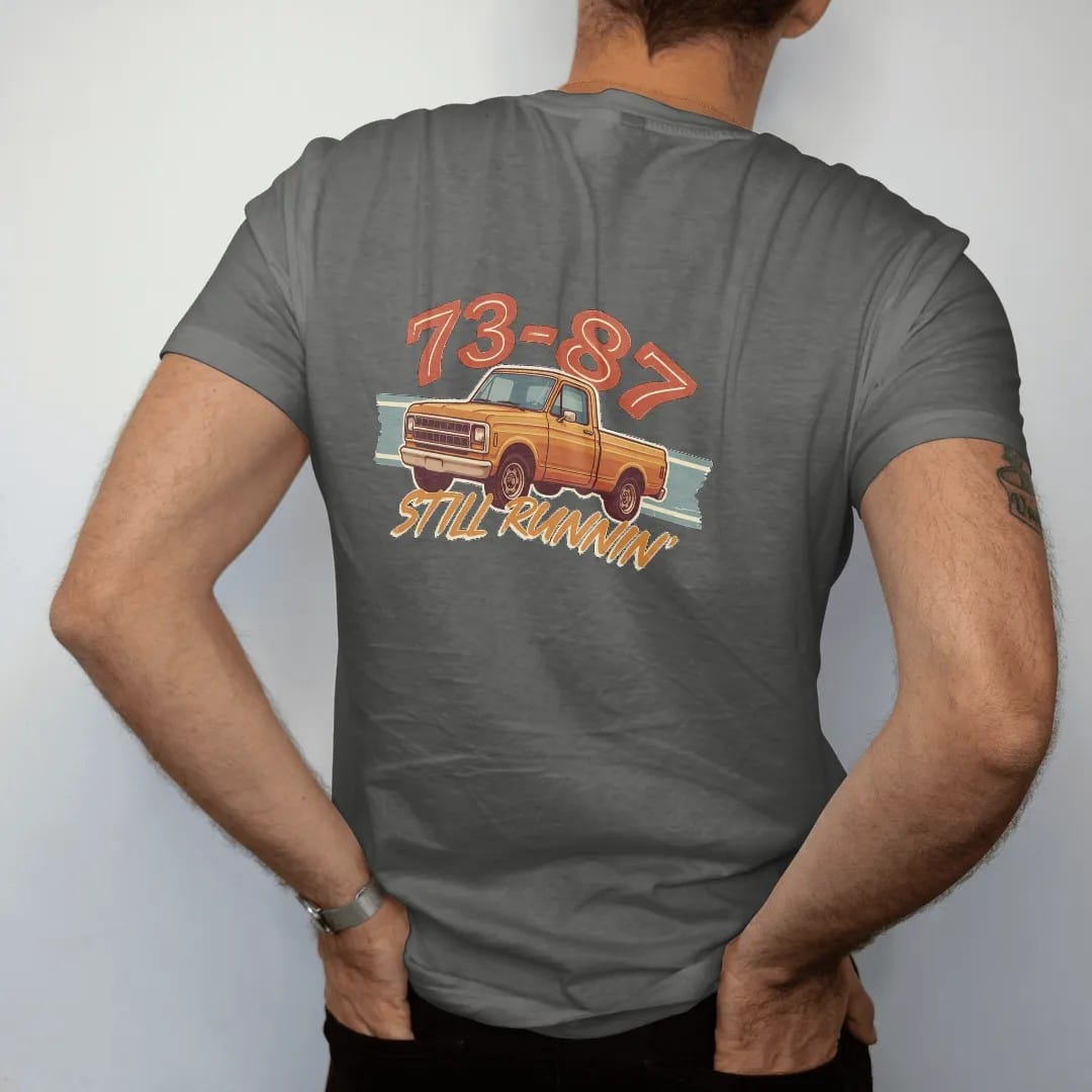 Man wearing a Pepper tee, seen from the back: a square-body pickup in front three-quarter view with 73-87 in big retro numerals above and Still Runnin' in brush script below.