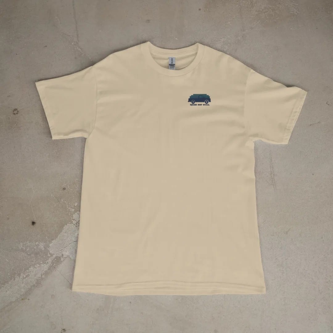 Front of a Sandstone tee laid flat, with the small Square Body Social logo on the left chest.