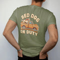 Man wearing a Moss tee, seen from the back: a floppy-eared hound riding in the bed of a square-body pickup with ears flying, under Bed Dog and over On Duty.