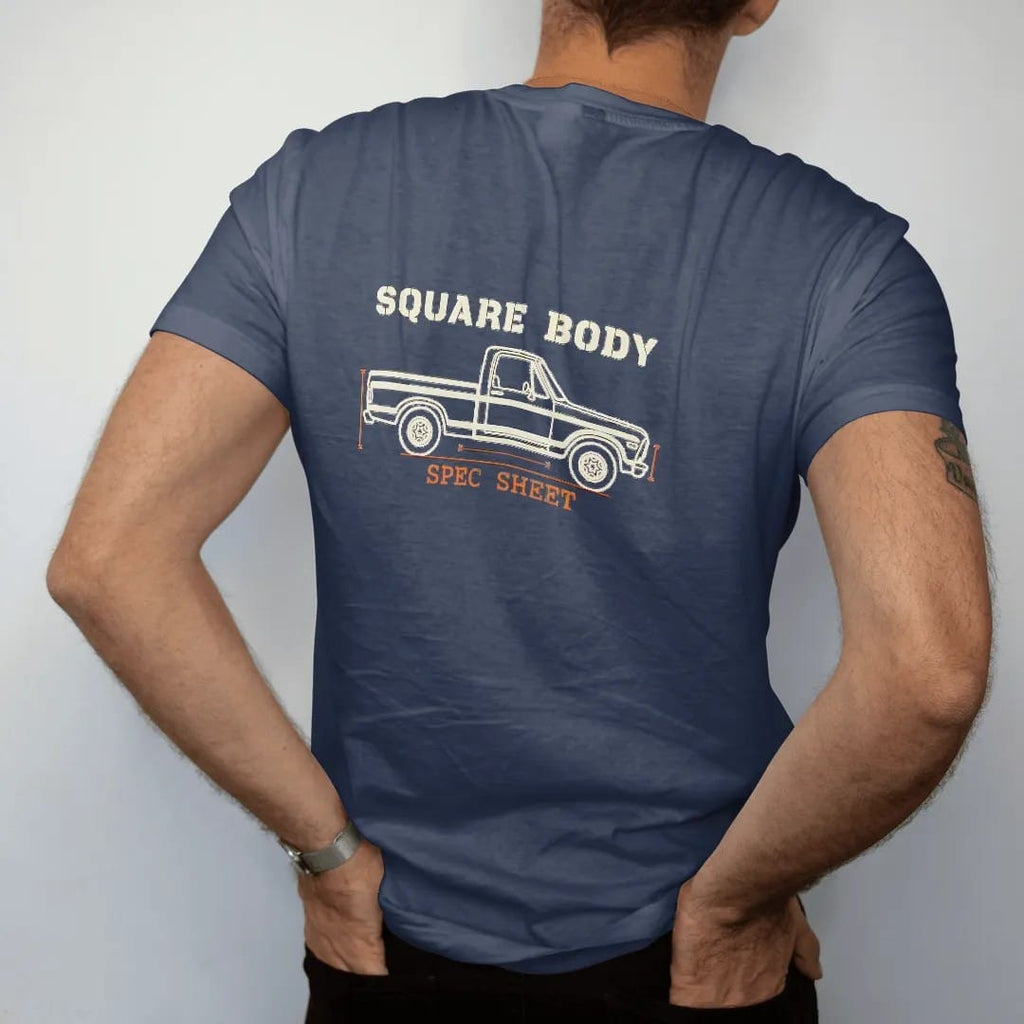 Man wearing a Navy tee, seen from the back: a cream line blueprint of a square-body pickup in side profile with dimension arrows, Square Body above and Spec Sheet below.