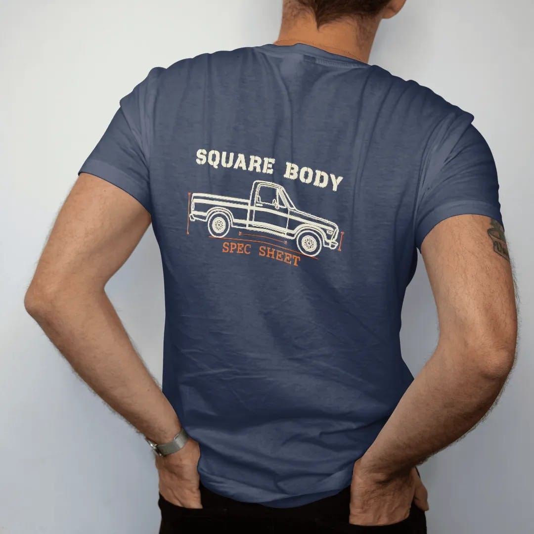 Man wearing a Navy tee, seen from the back: a cream line blueprint of a square-body pickup in side profile with dimension arrows, Square Body above and Spec Sheet below.