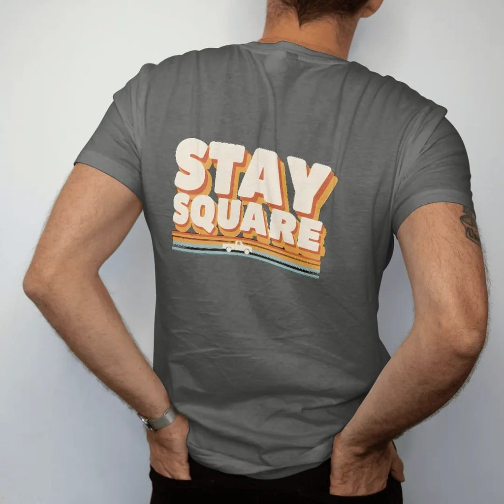 Man wearing a Pepper tee, seen from the back: a tiny square-body pickup riding 70s sunset stripes under Stay Square in giant cream block letters with an orange and gold drop shadow.