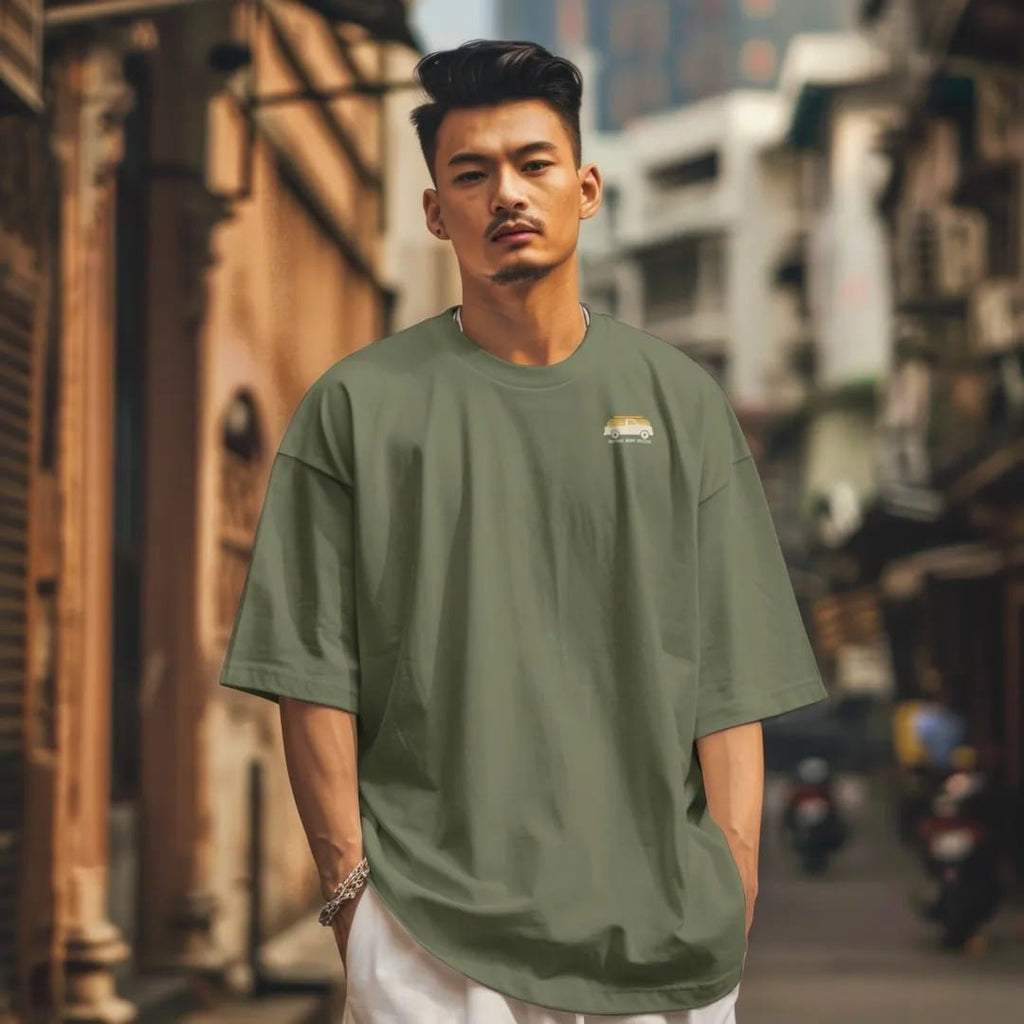 Man in a Moss tee on a city street, with the small Square Body Social logo on the left chest.