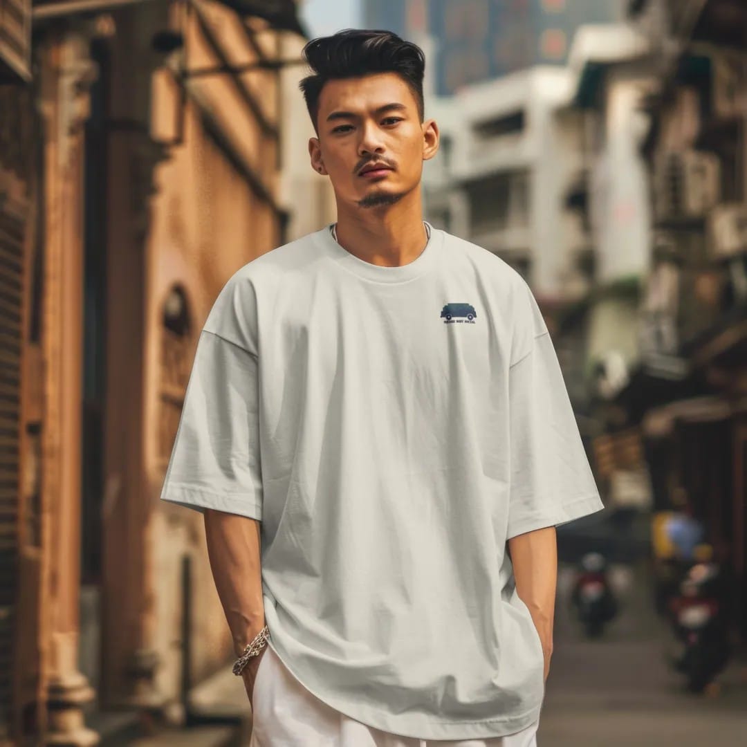 Man in a Ivory tee on a city street, with the small Square Body Social logo on the left chest.
